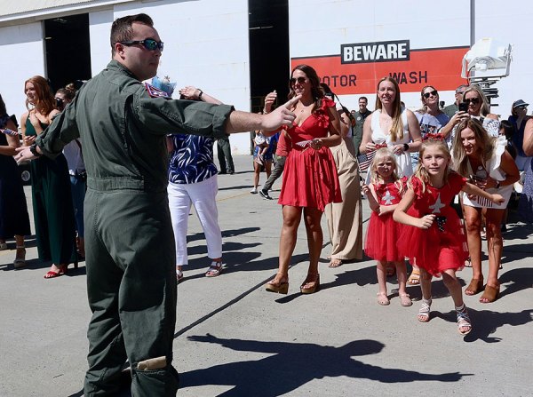 An attendant can't keep children away from their returning fathers as a pair Naval Air Station squadrons return home after a long deployment. 